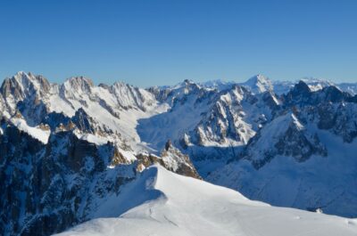A stunning view of Chamonix mountains covered in snow, under a clear blue sky.